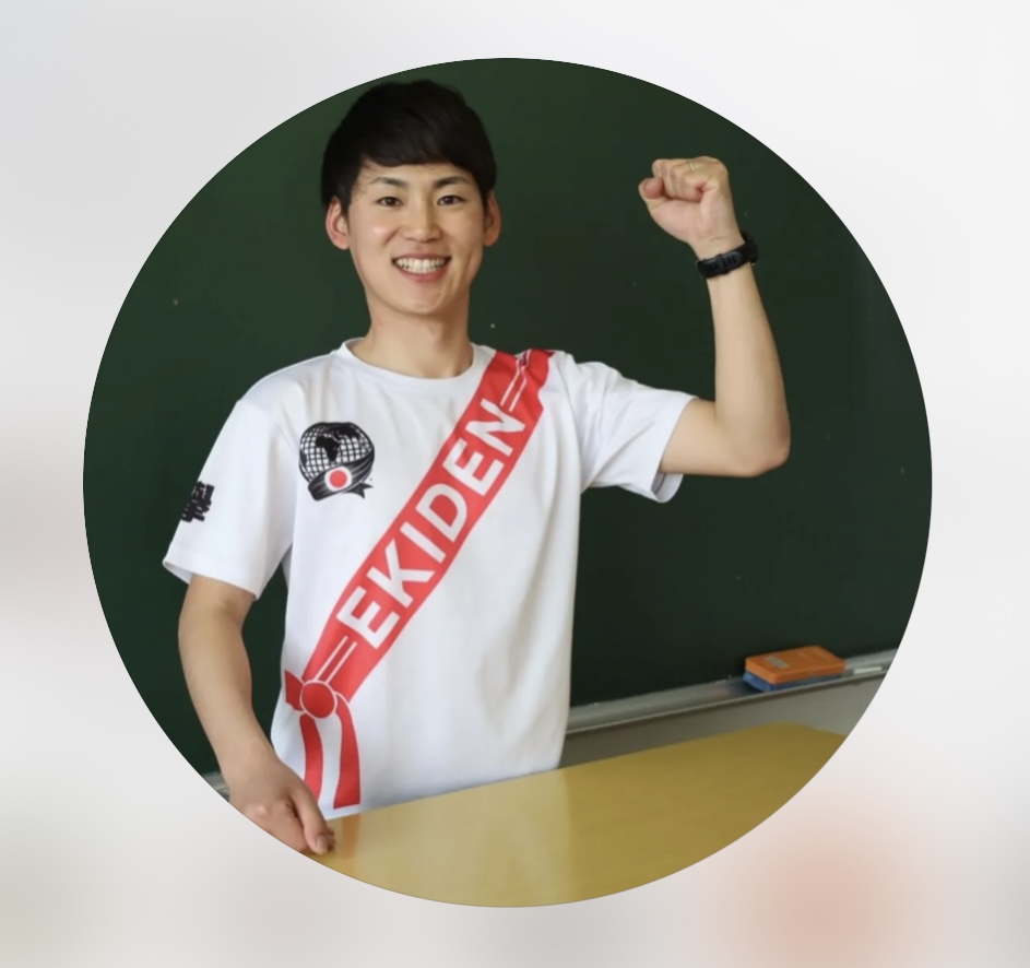 襷をかけて笑顔でガッツポーズする髙村敦史